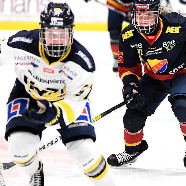 Två damhockeyspelare jagar efter pucken