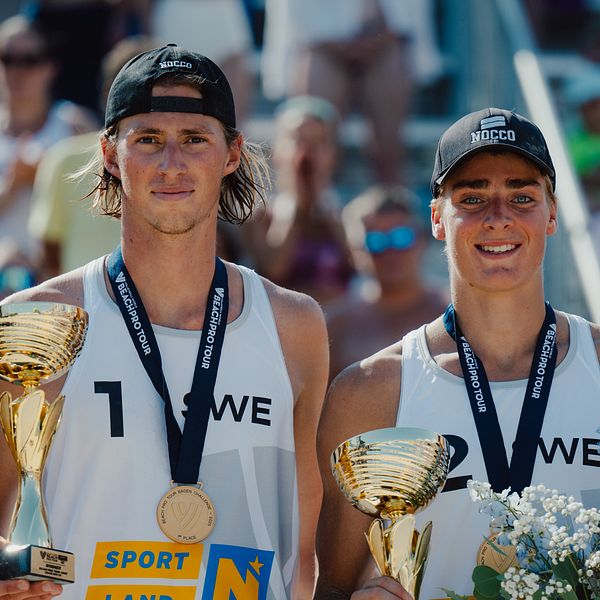 Jacob Hölting Nilsson och Elmer Andersson poserar med pokaler efter beachvolleybollseger.