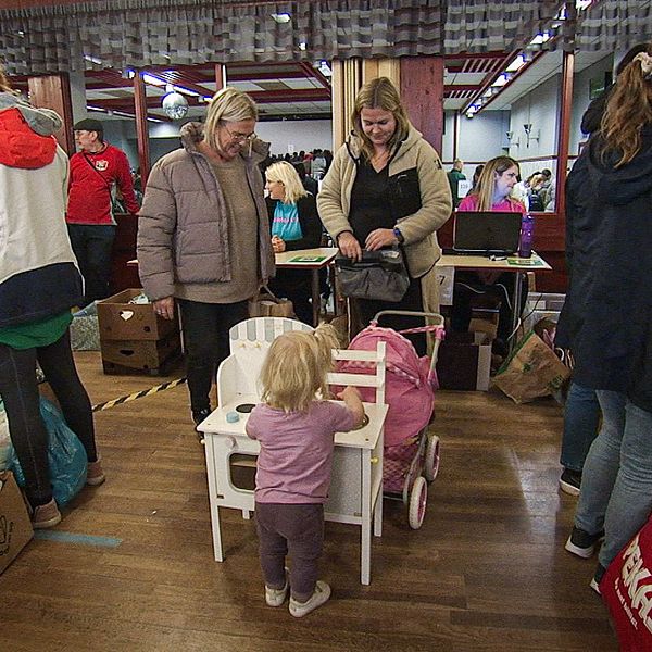 En familj med ett litet barn på stor barnloppis i Munkfors i Värmland.