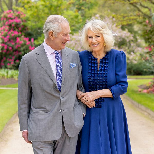 Kung Charles och drottning Camilla fotograferade i en trädgård.