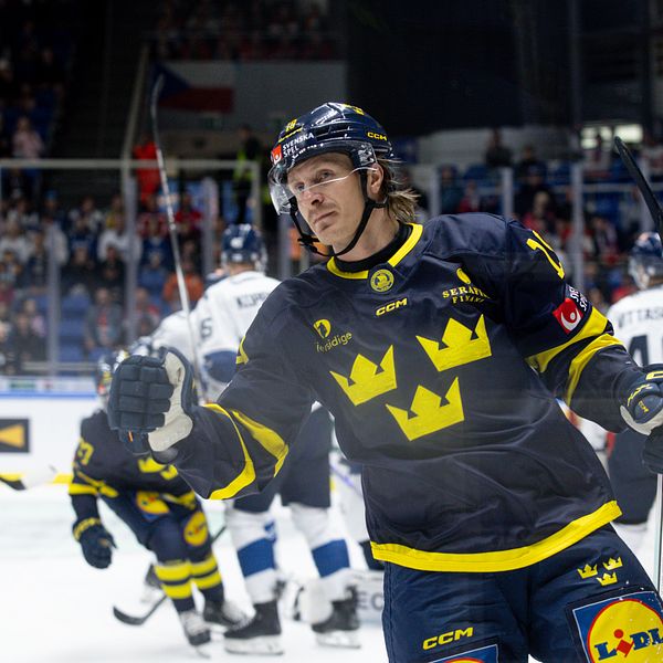 Svensk ishockeyspelare firar mål under landskamp mot Finland. Publik syns i bakgrunden.