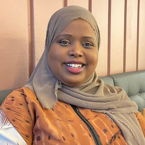 Khadra, en kvinna tittar in i kameran och ler