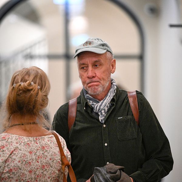 Håkan Nesser i tingsrätten, bredvid en kvinna i korridor