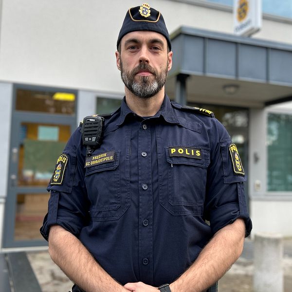 En polis som tittar rakt in i kameran.