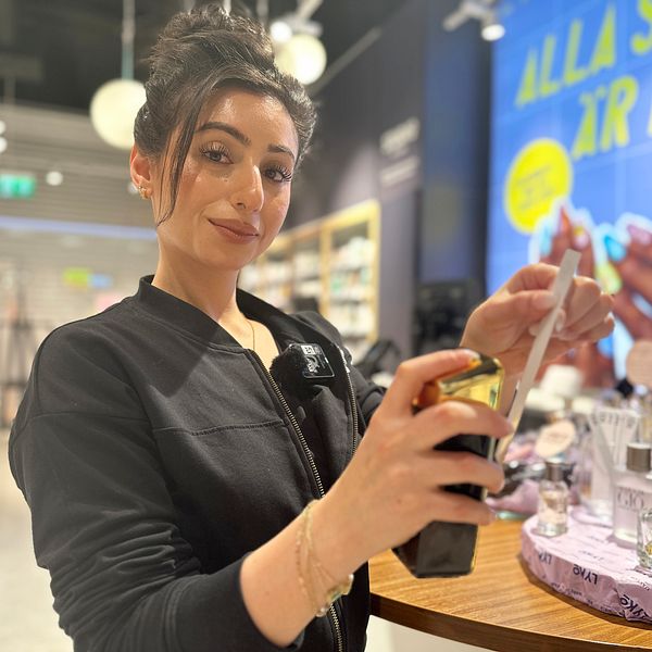 Butikschef Niveen Nouf på Lyko i Umeå sprutar en parfym som trendar på sociala medier