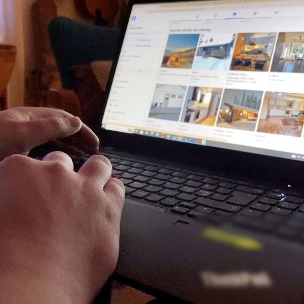 En person tittar på stugor på sociala medier framför en bärbar dator