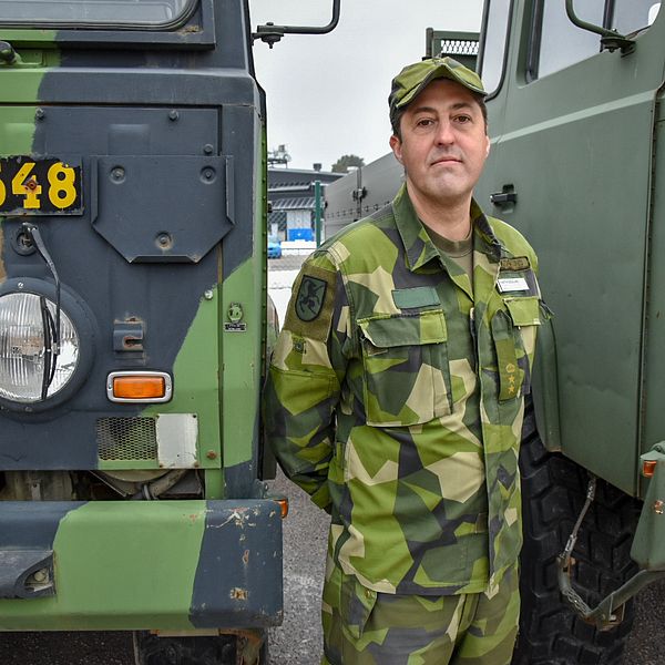 Martin Skoglund framför två militärfordon.