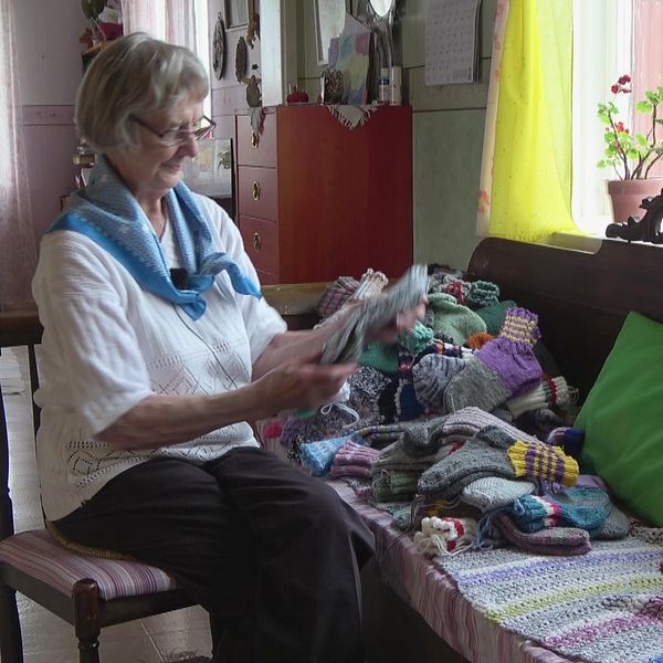 Ebba Hansson, 97 år,  visar upp sockarna hon har stickat för att skicka till Ukraina.
