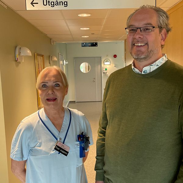 En kvinna och en man står bredvid varandra och ler.