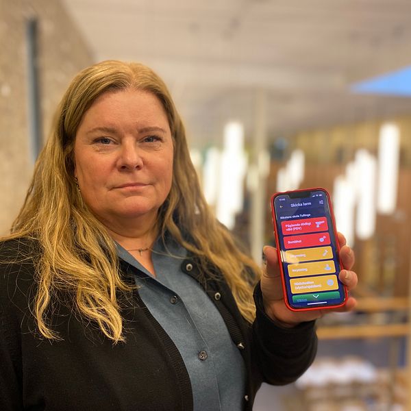 En kvinnlig rektor med en mobil sin hand.