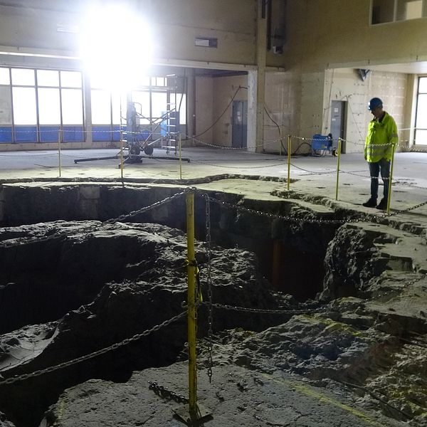 En man som står framför ett stort hål i betong, där en reaktor tidigare har varit.