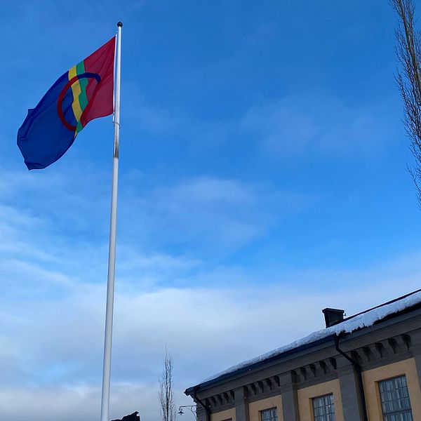 samisk flagga och husfasad i bakgrunden