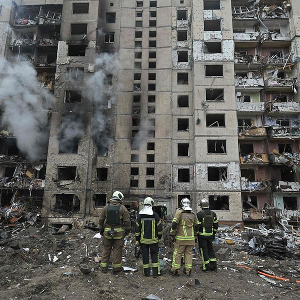 Brandmän framför förstörd byggnad i Kiev, Ukraina