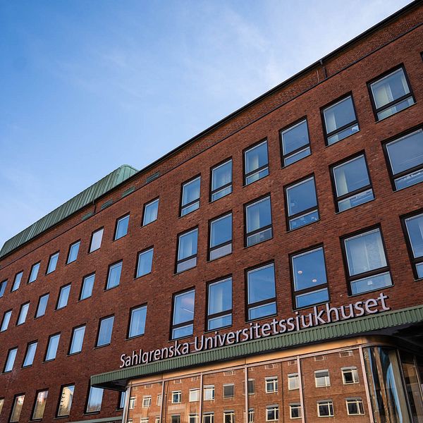 Ett stort hus syns mot blå himmel, på huset syns en skylt med texten Sahlgrenska universitetssjukhuset.