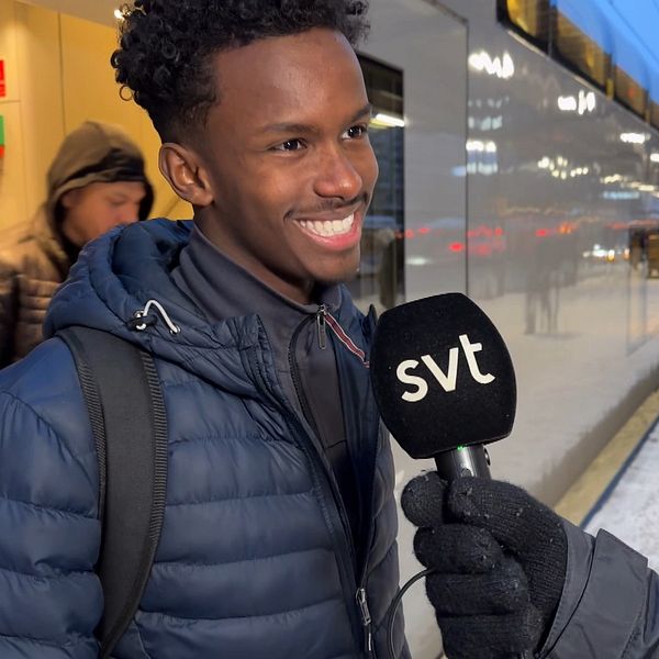 En ung man blir intervjuad vid sidan av ett tåg på Centralstationen i Örebro.