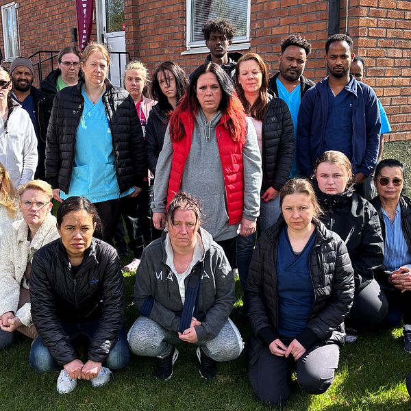 Gruppbild utomhus med vårdpersonal framför en tegelbyggnad.