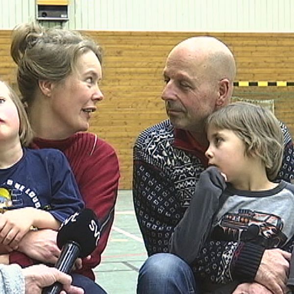 en familj med två vuxna och två barn i en gymnastiksal
