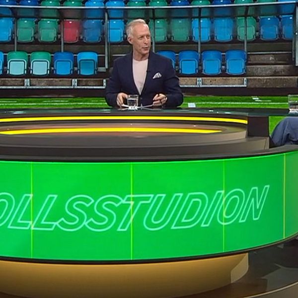 Tre personer diskuterar i en TV-studio med ”Fotbollsstudion” på bordet.