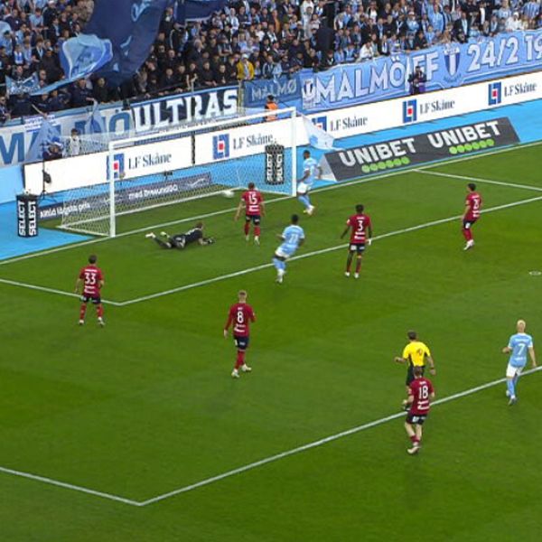 Fotbollsspelare från två lag vid straffområdet, bollen precis bakom mållinjen.