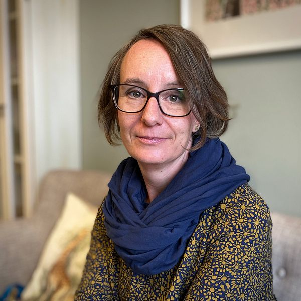 Linda Johannesson, en kvinna med brunt hår och glasögon sitter i en soffa på Centrum mot våld i Östersund.