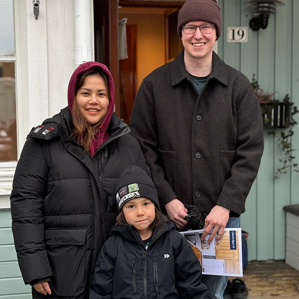 Familj står utanför hus med vinterkläder. De har varit på husvisning.