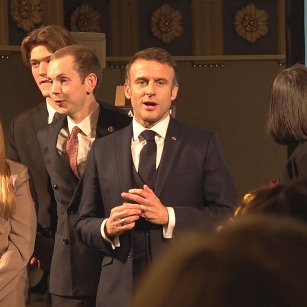 Frankrikes president Emmanuel Macron omgiven av studenter