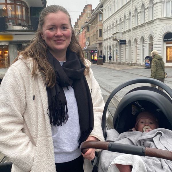 Sandra Bälgwik står i centrala Eskilstuna intill sin dotter i en barnvagn.