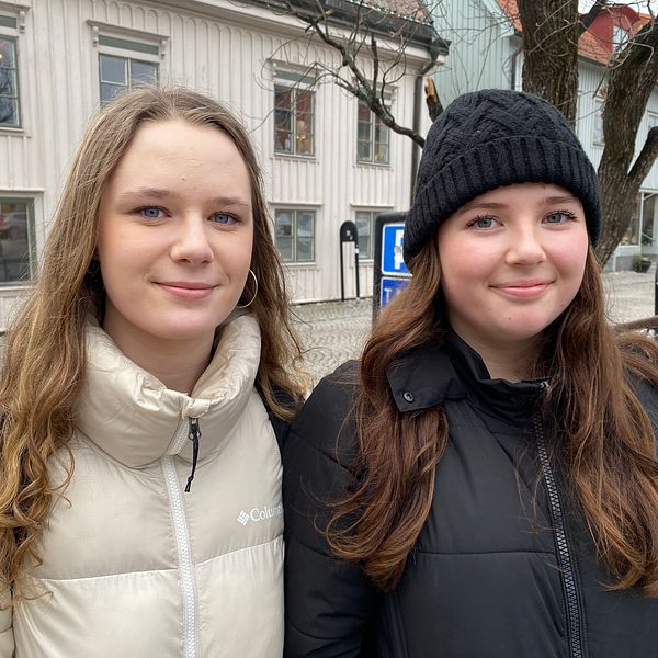 Estelle Bäckström och Emilia Björk står på torget i Mariefred. De har vinterjackor på sig och ser glada ut.