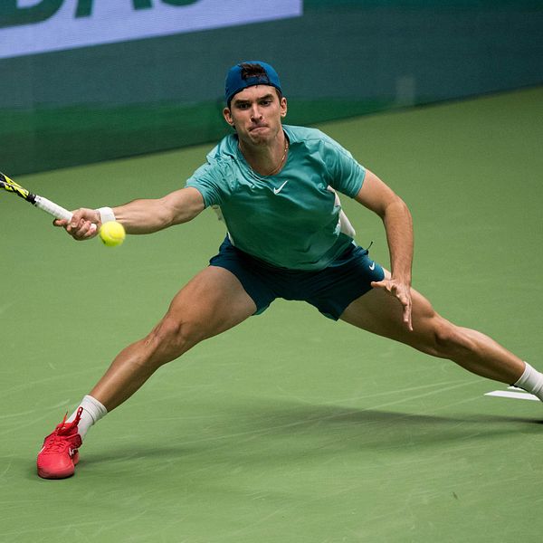 Tennisspelaren Dino Prizmic sträcker sig efter en boll.