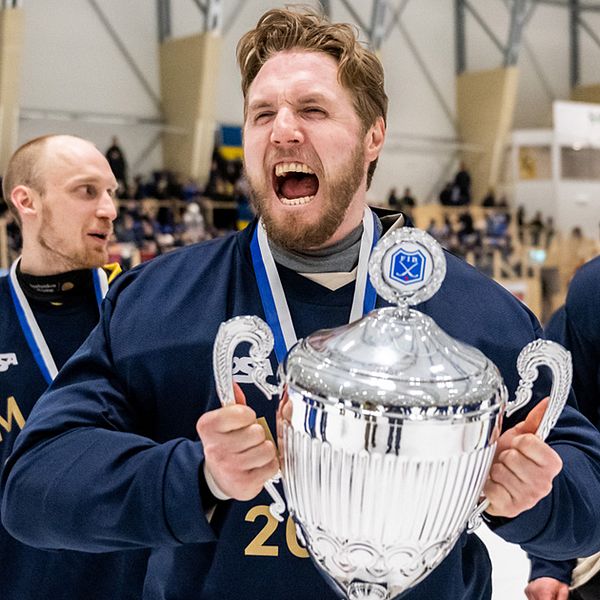 Lag i VM-tröjor firar mästerskapsvinst med pokal och medaljer.
