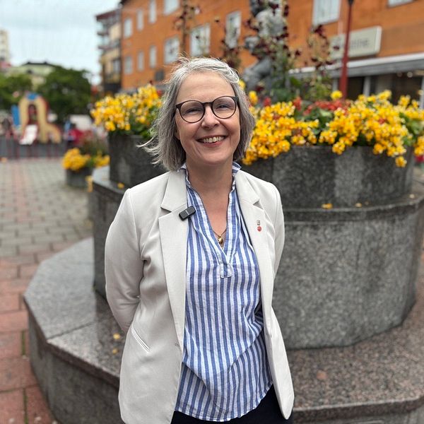 Bodens kommunalråd står vid blomsterplantering i Boden och ler mot kameran.