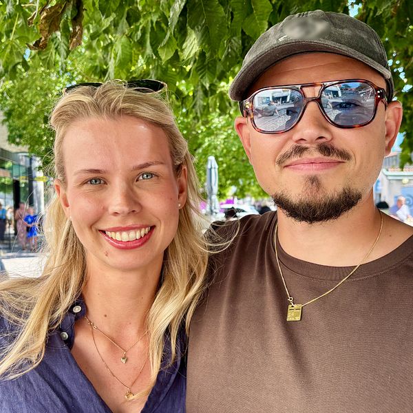 Olivia Hamberg och en man poserar på en gata i sommarvärme