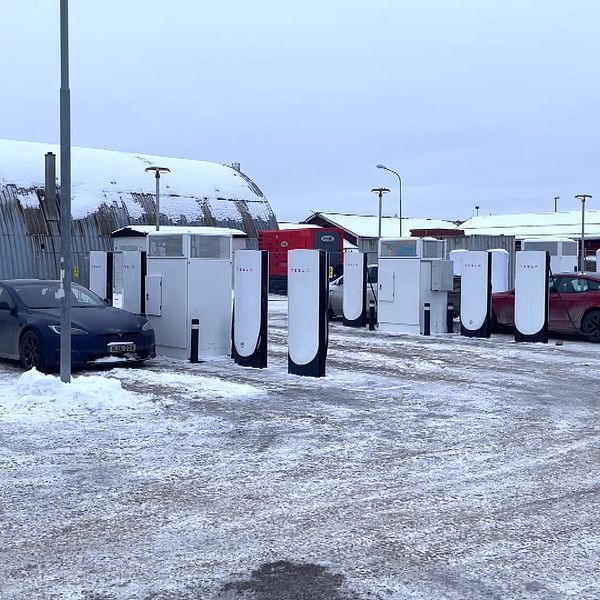 Teslas laddstationer i Vansbro med två bilar parkerade vid laddarna vintertid.
