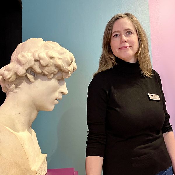 Angelica Blomhage står bredvid en skulptur