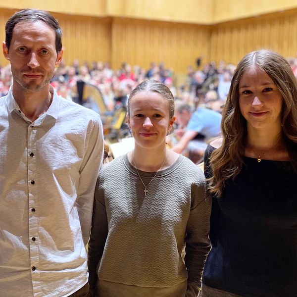 en man och två tjejer står framför en kör
