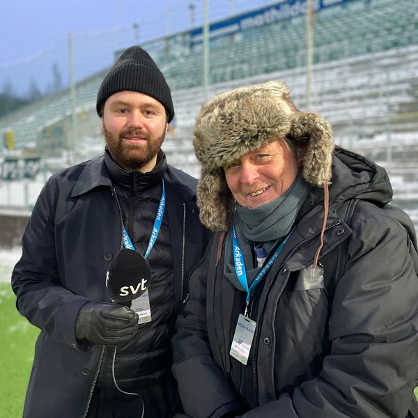Två väl påpälsade reportrar står på IP framför en snöig hemmaläktare.