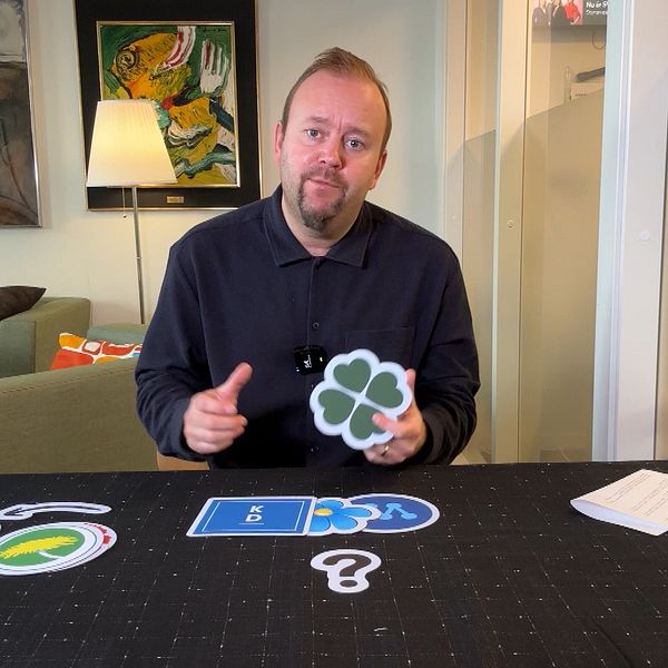 SVT-reportern Kristofer Ström vid ett bord med valkort och symboler