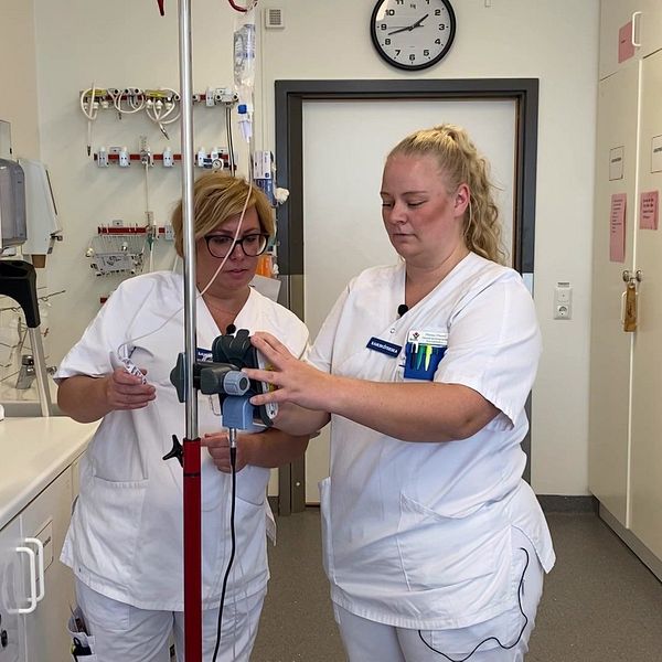 Två sjuksköterskor ställer in en droppställning på sjukhuset i Västerås.