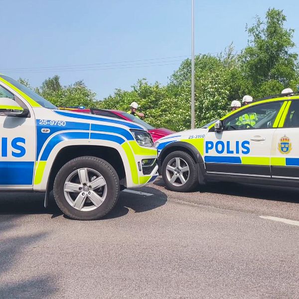Två polisbilar står med nosen mot varandra vid en olycksplats.
