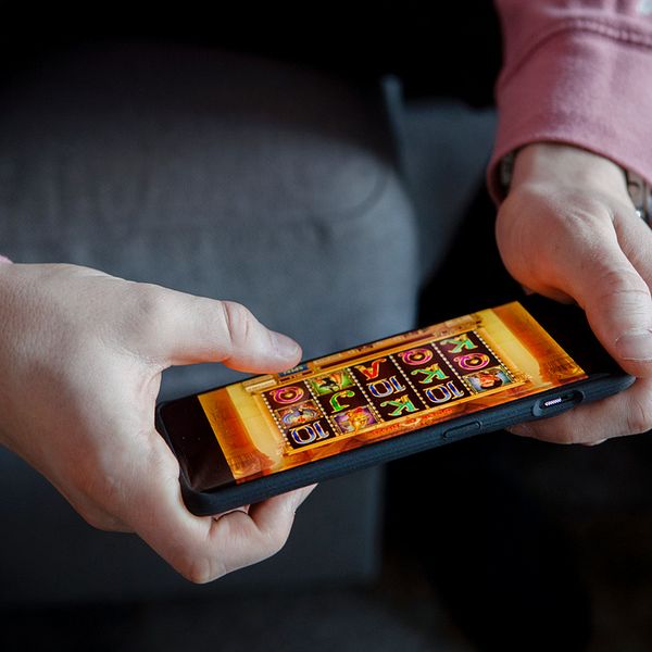 Person som spelar casinospel på en telefon.