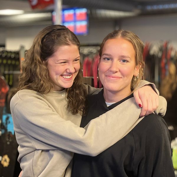 Hilda Wadsborn Taube och Vilma Holmqvist står och håller om varandra inne en skiduthyrning i Åre.
