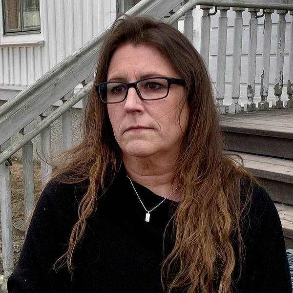 kvinna med svart tröja framför trappa.
