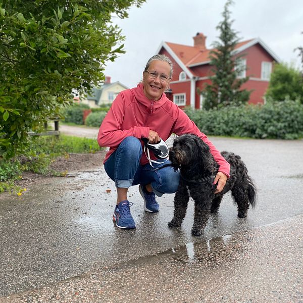 Kvinna med hund framför hus i bostadsområdet Hemsta i Gävle