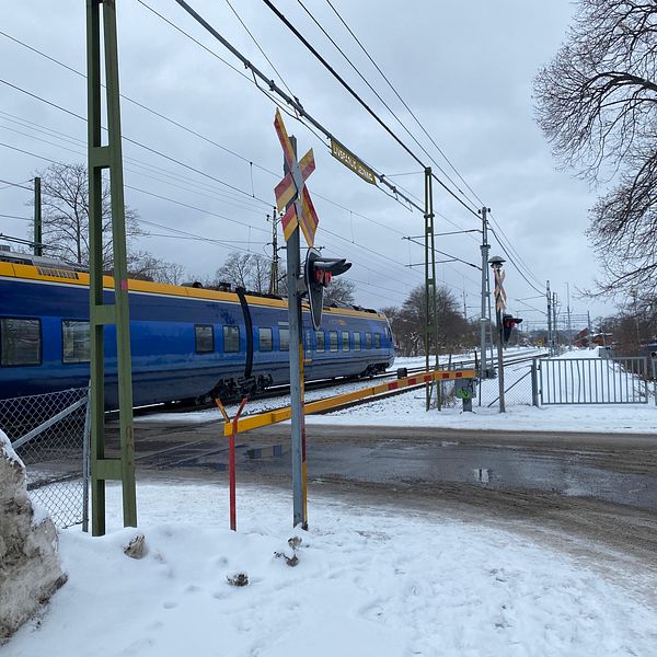Ett passagerartåg passerar plankorsningen vid Floragatan i Sundsvall