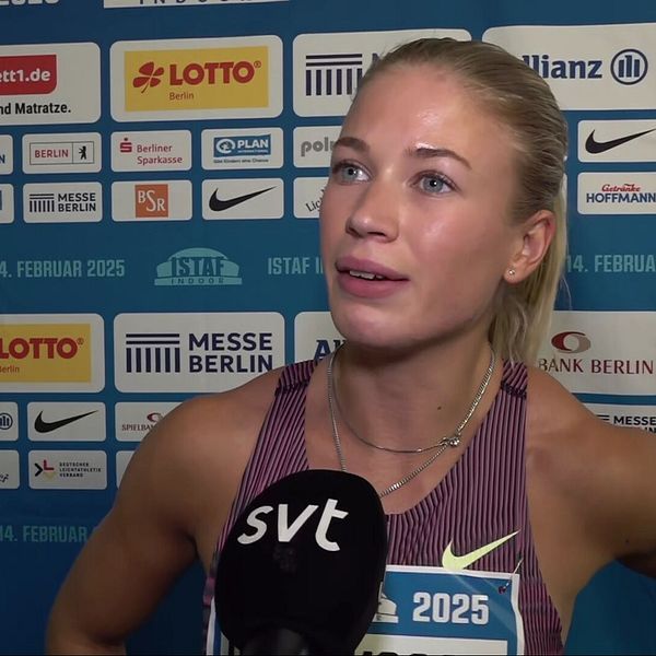 En idrottare, iklädd sportkläder med nummerlapp ”2025”, intervjuas av SVT. I bakgrunden syns en sponsorvägg fylld med logotyper från olika företag såsom Lotto, Nike, och Allianz.