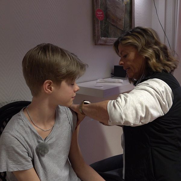 En pojke får en spruta i armen av en sjuksköterska
