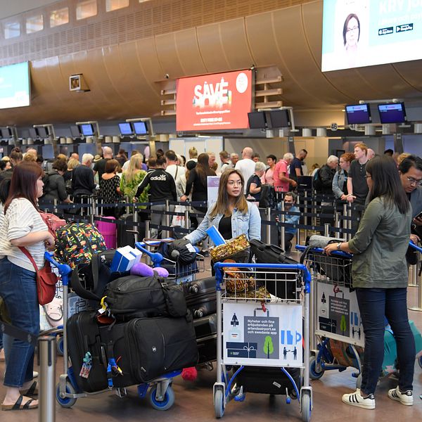 Personer som står och väntar på att checka in bagage på en flygplats.