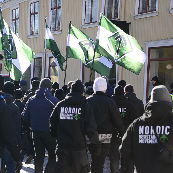Demonstranter med gröna flaggor marscherar på en gata.