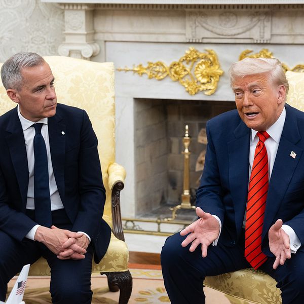Donald Trump och Mark Carney samtalar formellt i ett elegant rum med öppen spis och marmordekor.