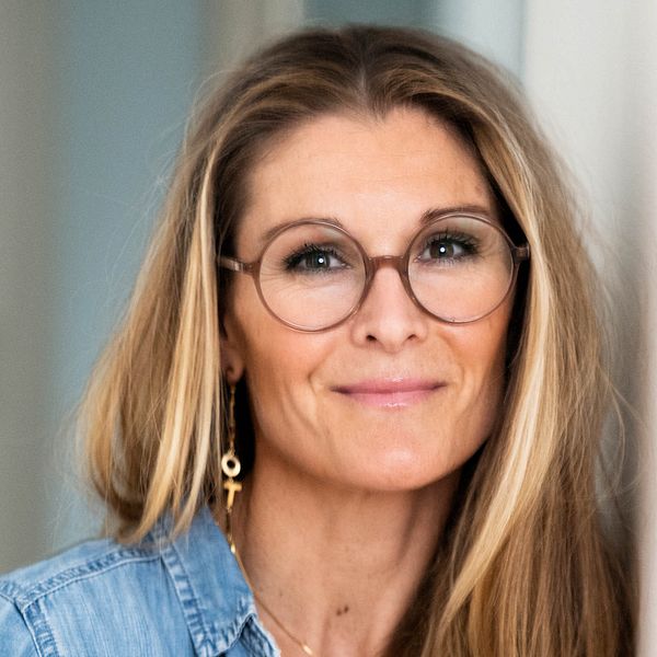 Lotta Borg Skoglund porträtterad i glasögon och jeansskjorta